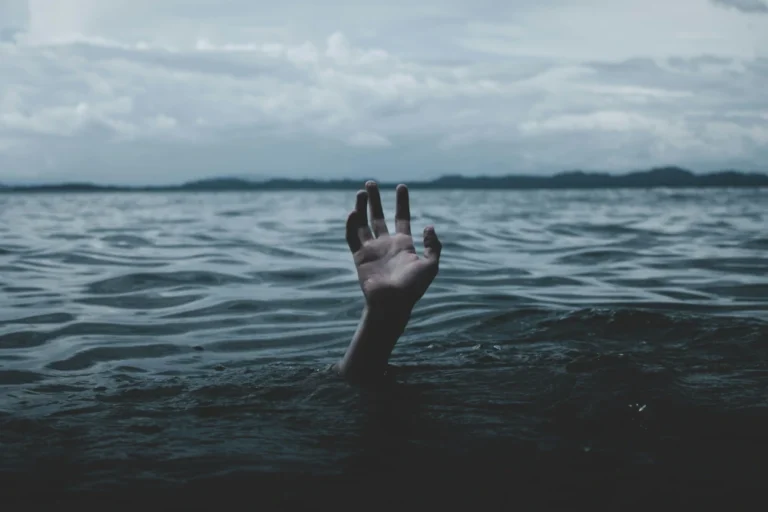 Bild einer Hand, die aus dem Wasser raus schaut, ohne dass man den Rest des Körpers sieht.