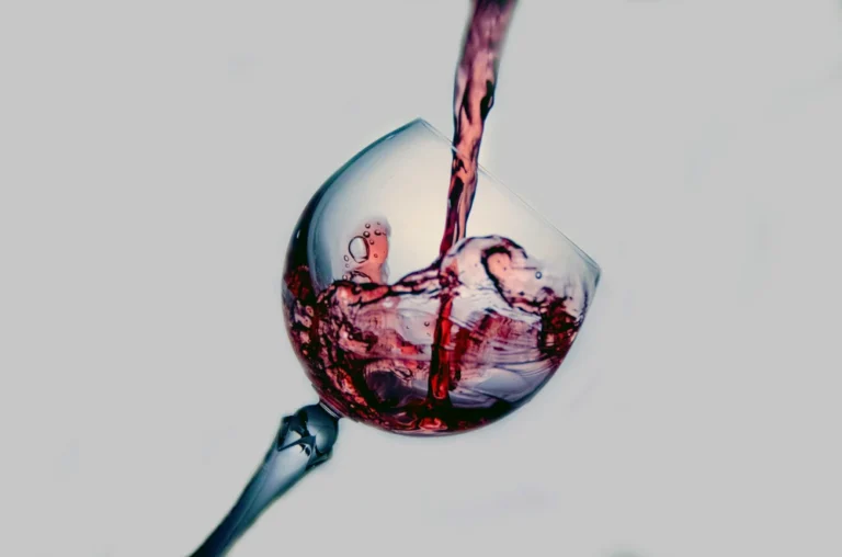 Bild von einem Weinglas, das mit Rotwein gefüllt wird